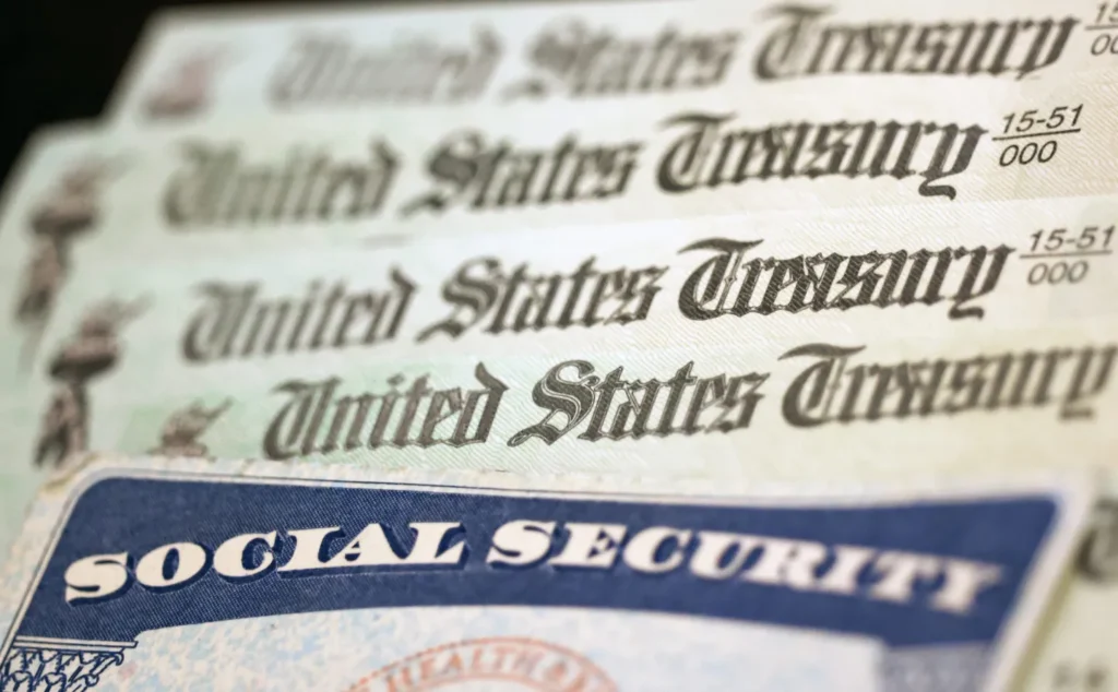 Close-up of United States Treasury checks fanned out over a Social Security card