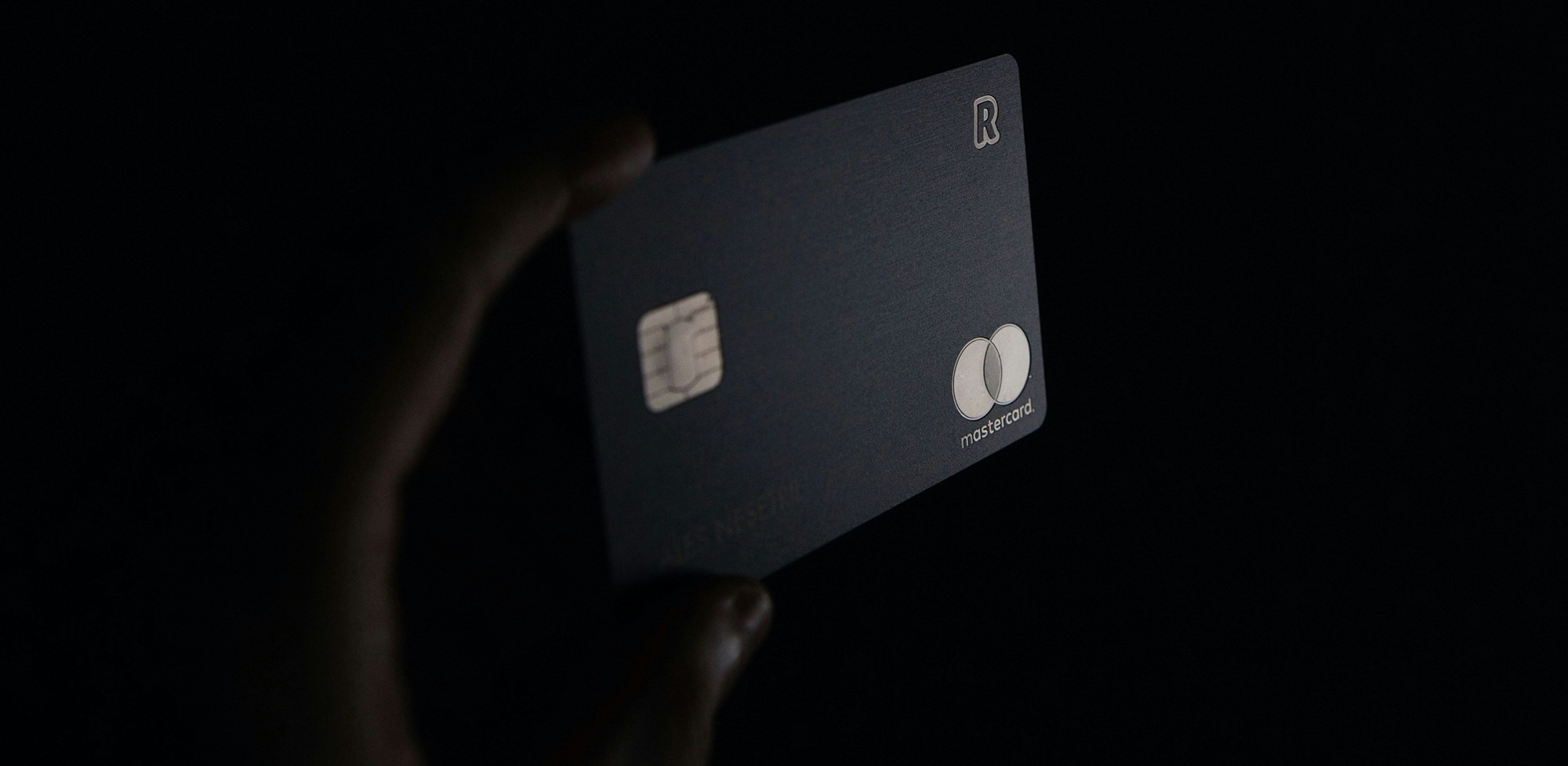 Hand holding a bank card in the dark