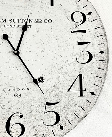 A close-up of an antique clock face, marked Sutton and Co, Bond Street, London, 1894