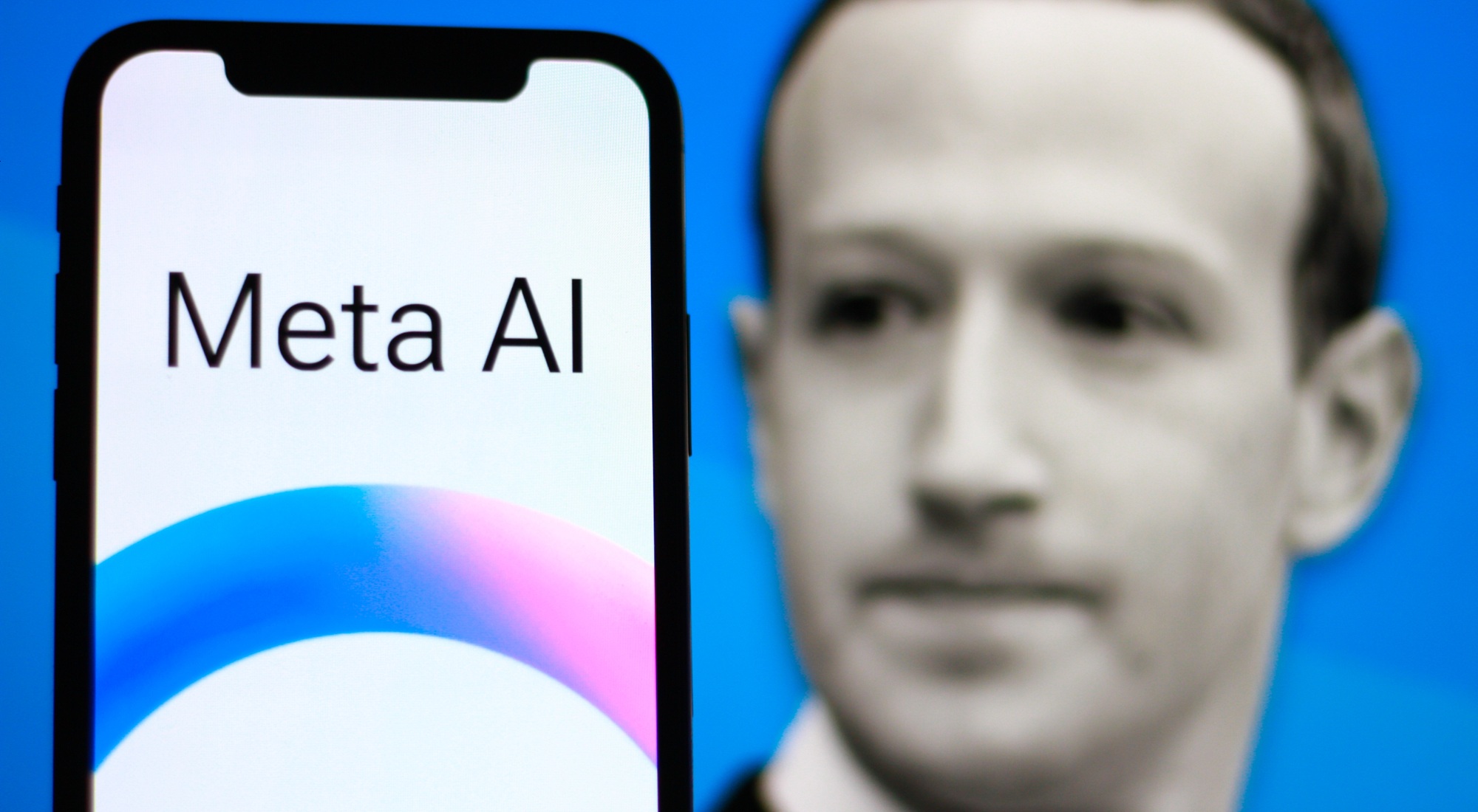 A phone showing the Meta AI logo, with a blurred photo of Mark Zuckerberg on the screen behind it