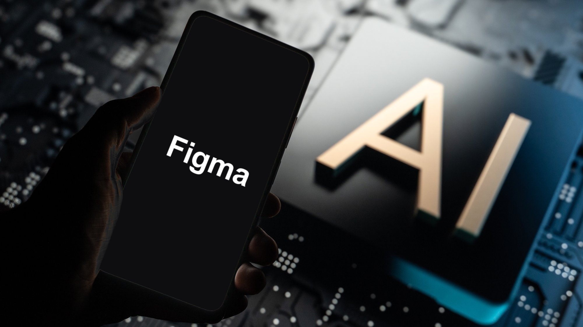 A hand holding a phone that says Figma on a black screen, in front of a chip marked AI