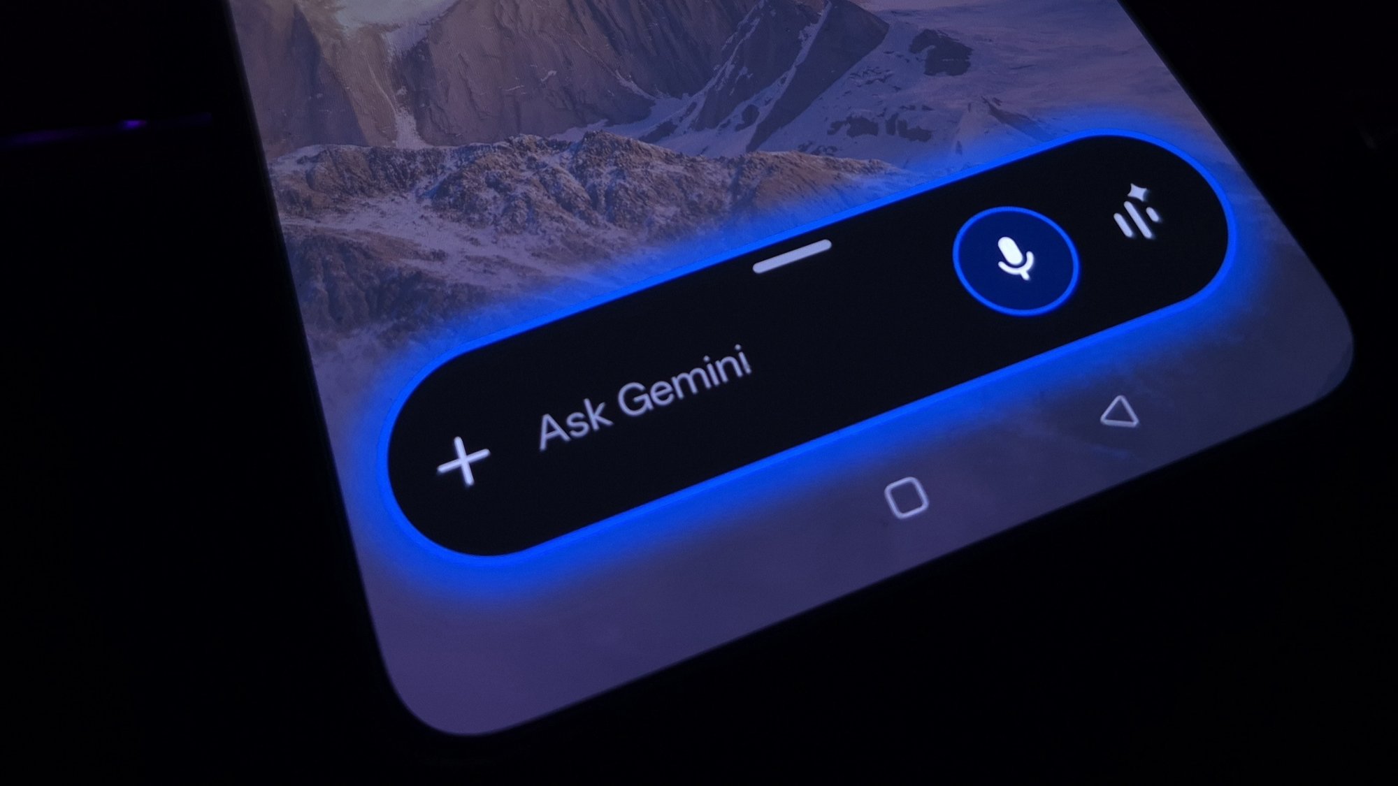An Android phone with the Ask Gemini bar glowing blue across the bottom of the screen
