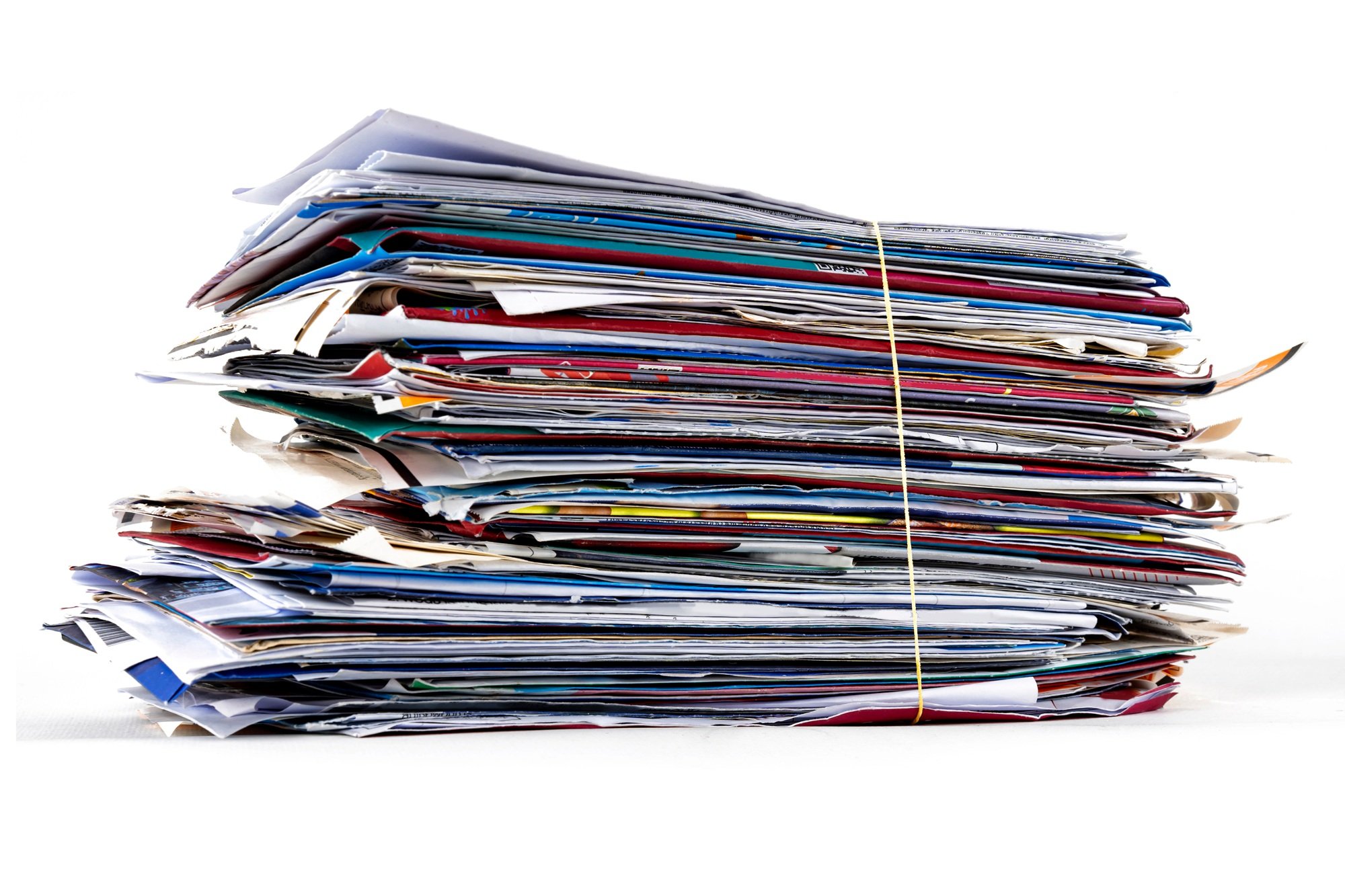 A thick stack of junk mail, catalogs and envelopes bundled with a rubber band