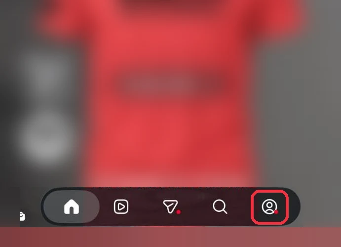 Instagram's home feed, blurred, with the profile button at the bottom right boxed in red