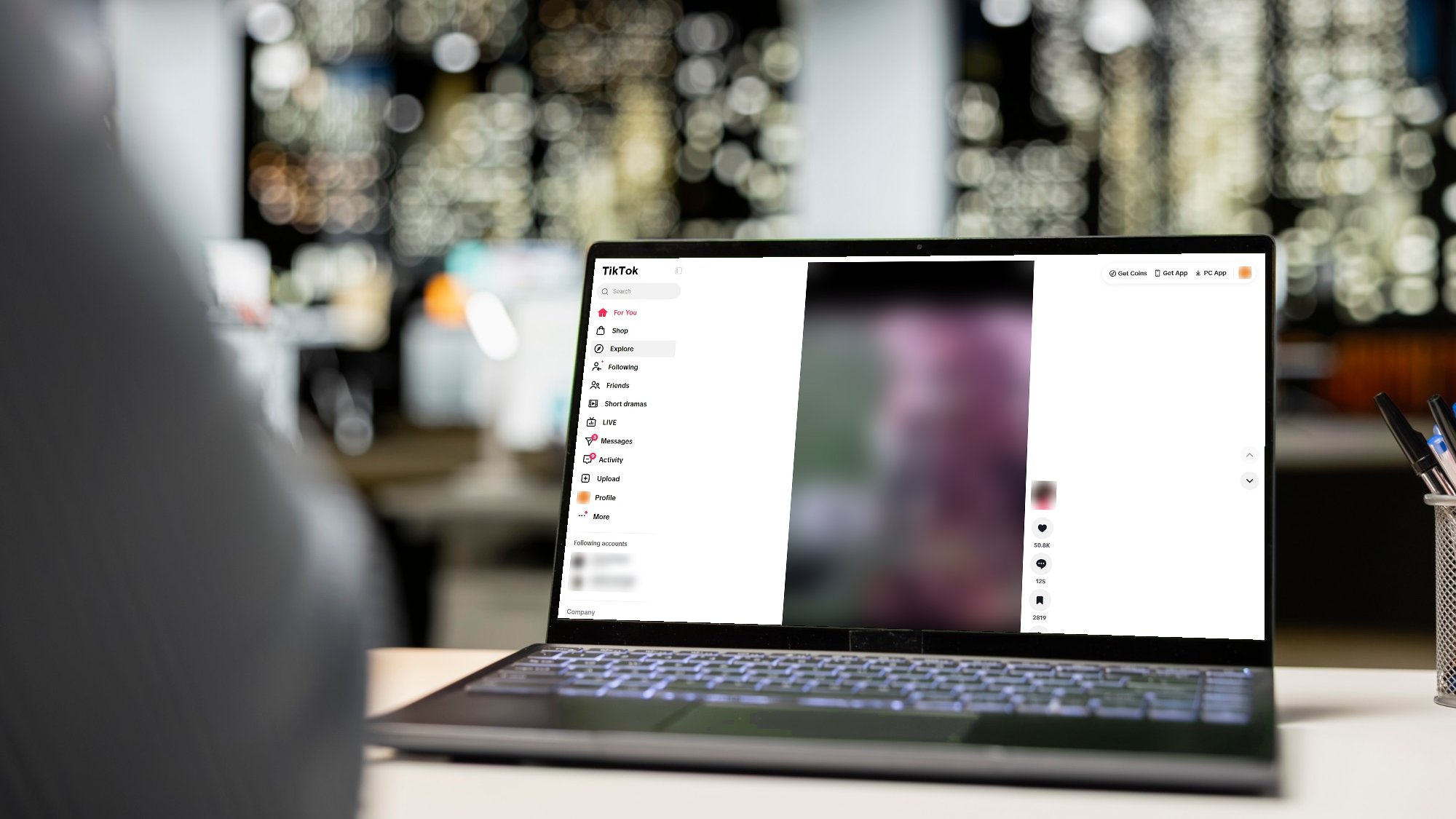 A laptop on an office desk showing the TikTok website