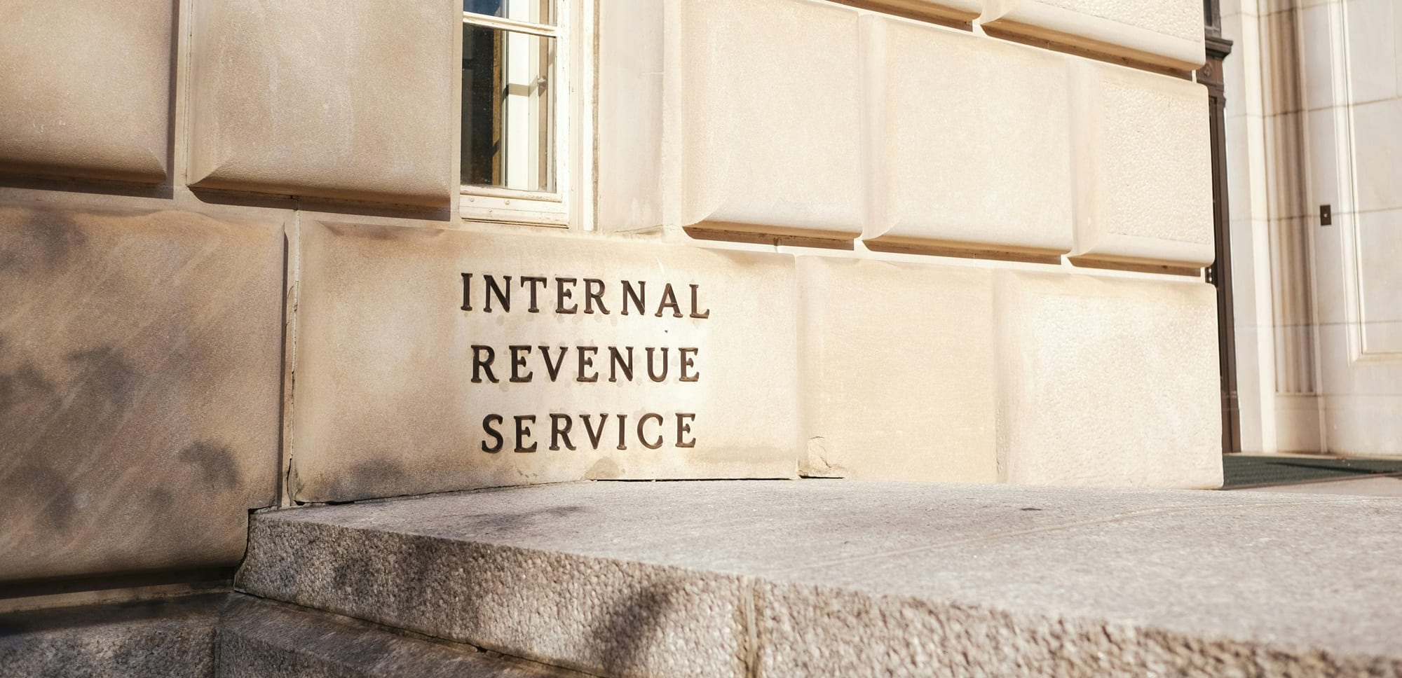 INTERNAL REVENUE SERVICE carved into the stone front of the IRS building, seen from the steps